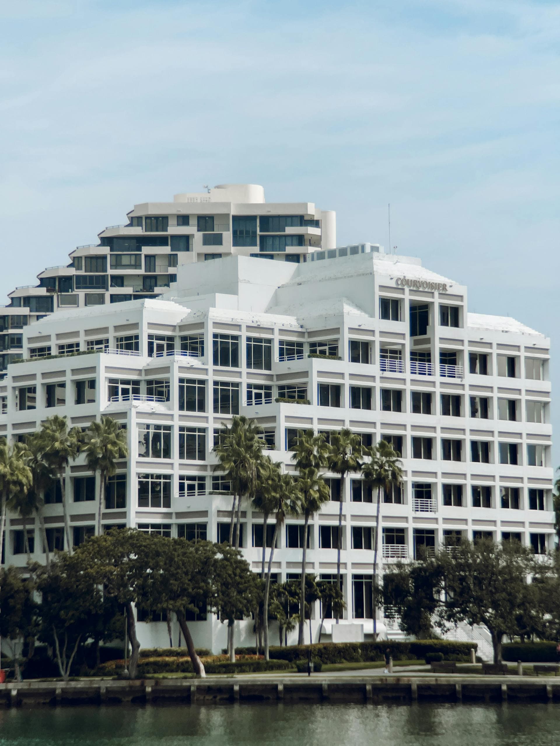 Modern white waterfront building with palm trees in Miami Florida