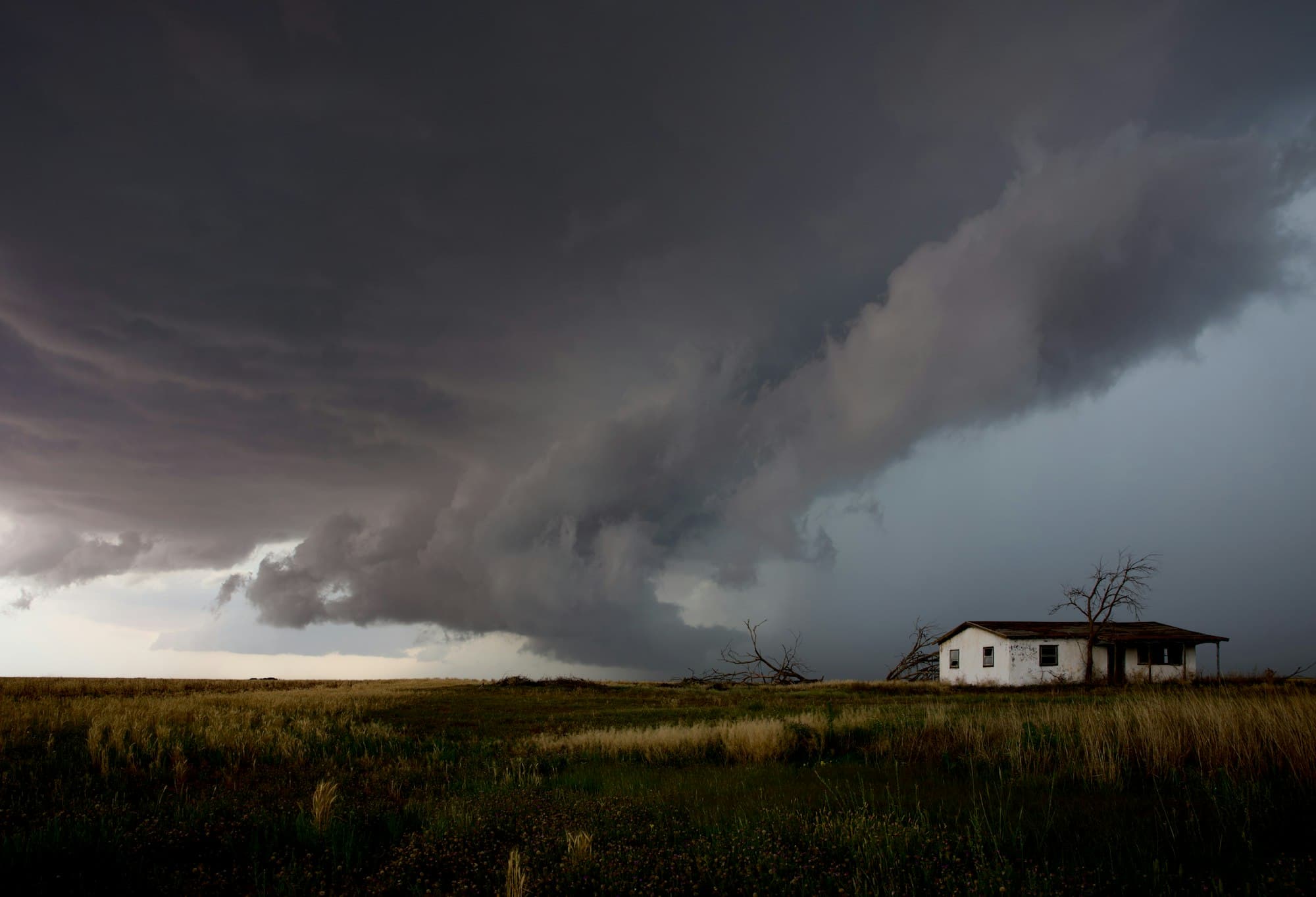 Dramatic Texas storm clouds approaching a house in the wide-open landscape