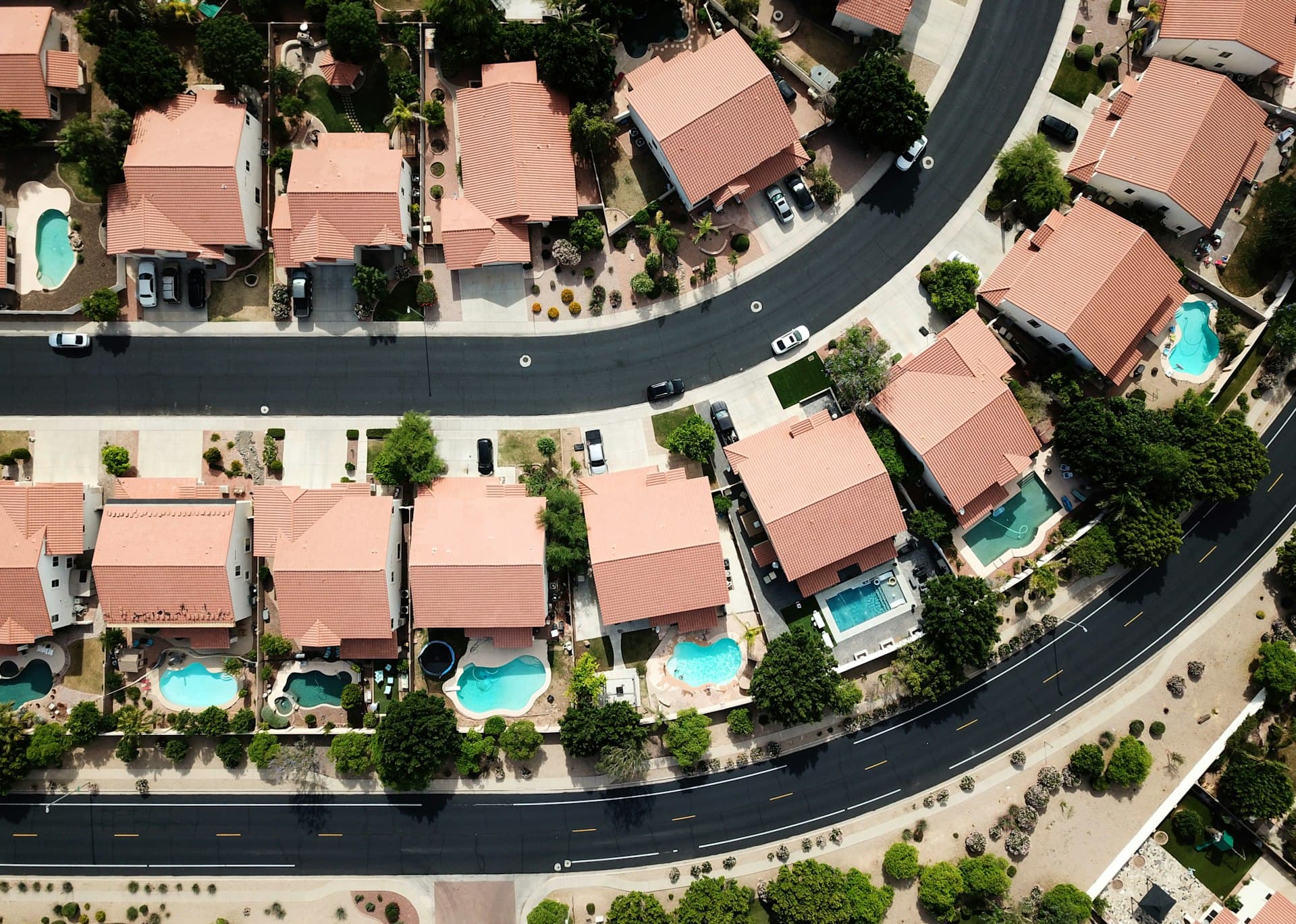Aerial view of Arizona subdivision with tile-roofed homes and backyard pools