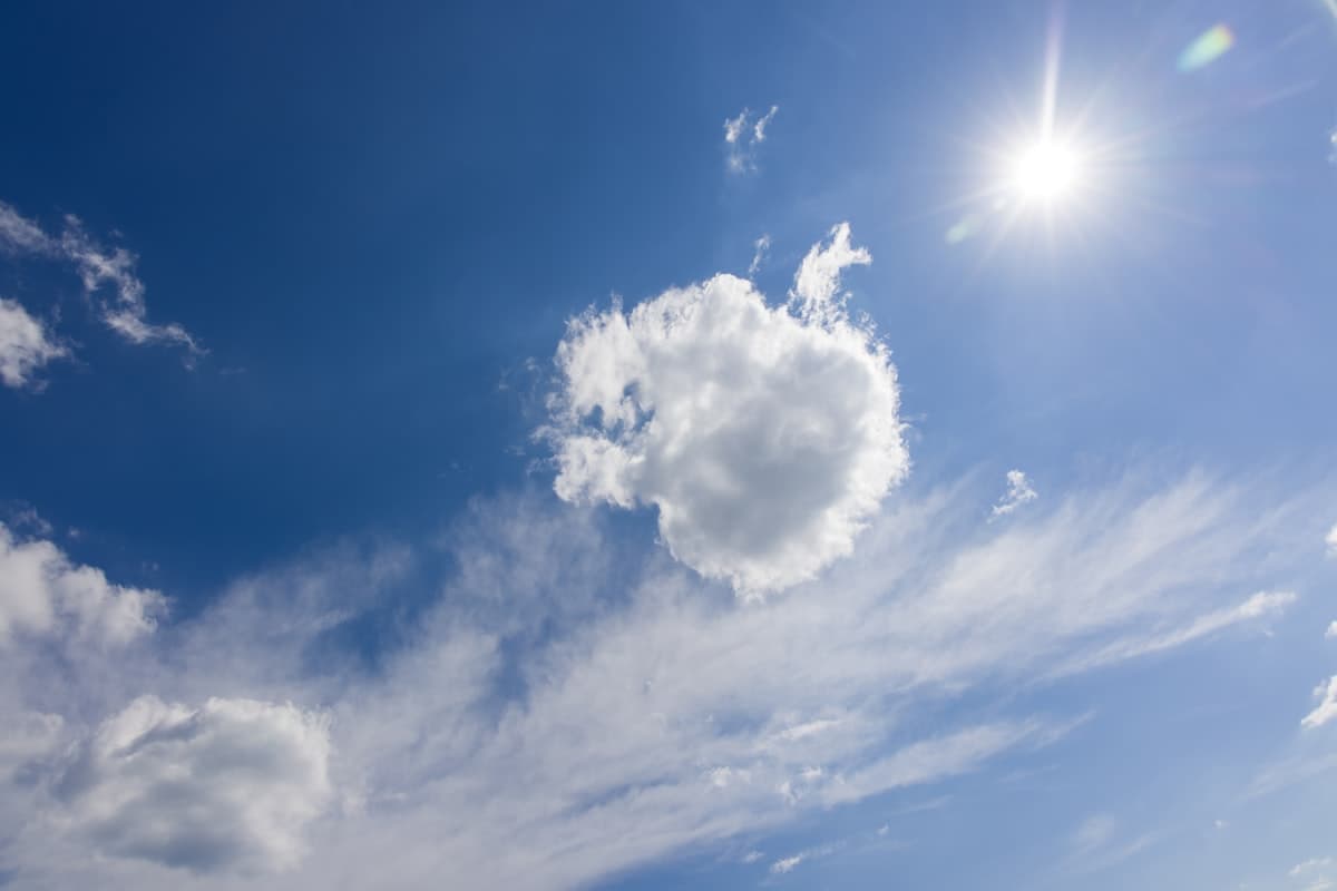Bright sunny Texas sky with sun and white clouds representing summer heat