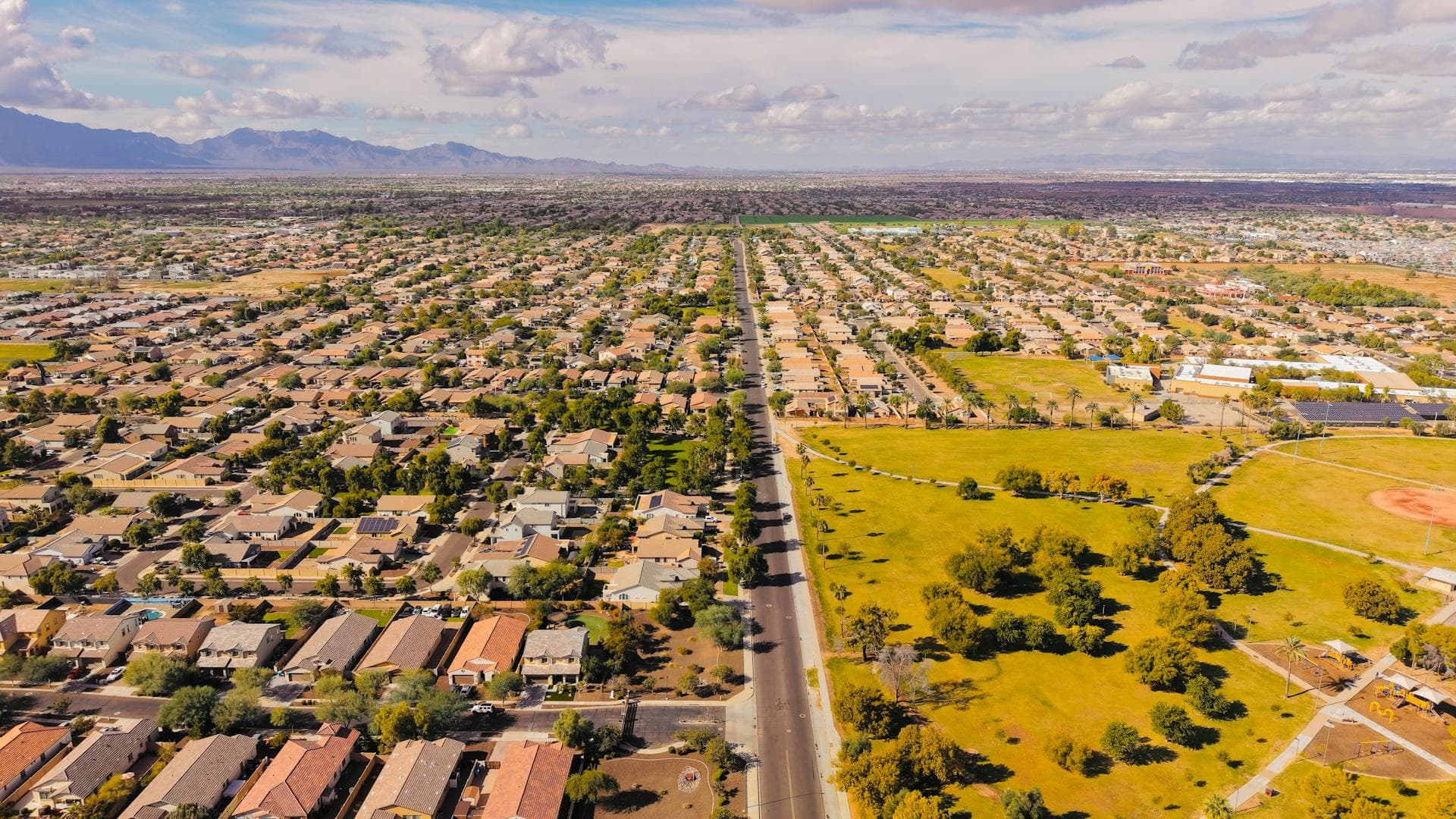 Aerial view of suburban Arizona neighborhood with tile roof homes and parks